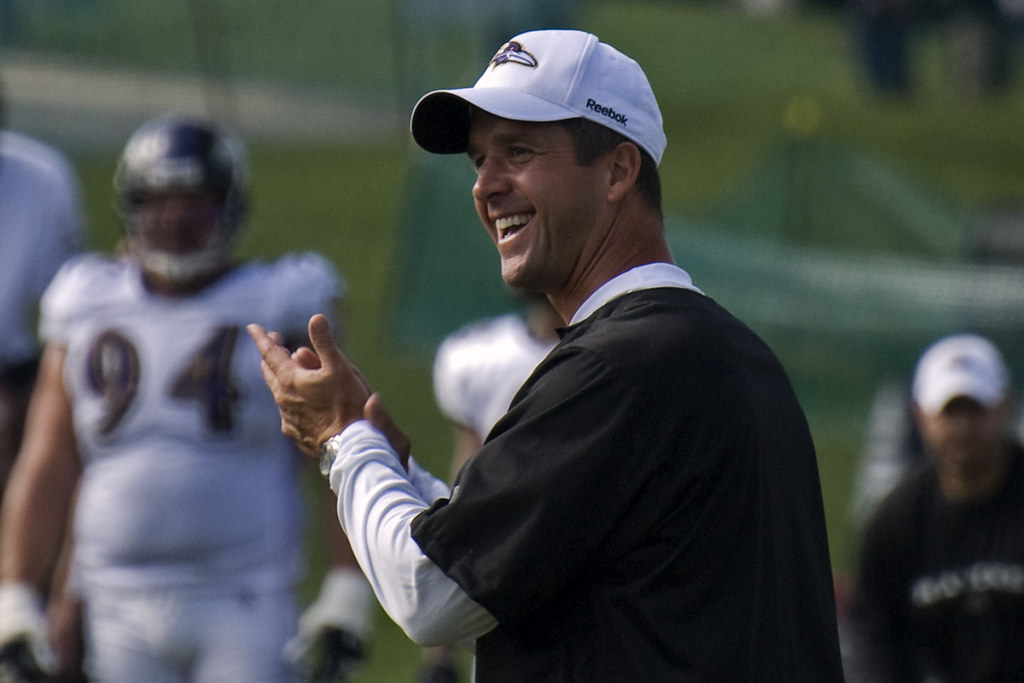 Smiling academy coach applauding players mid-session