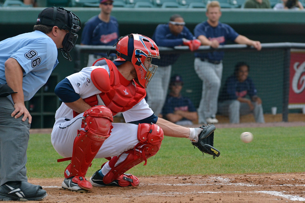 Junior catcher in red gear focused before the pitch