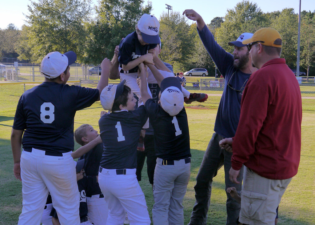 Junior players lifting a teammate in celebration on the field