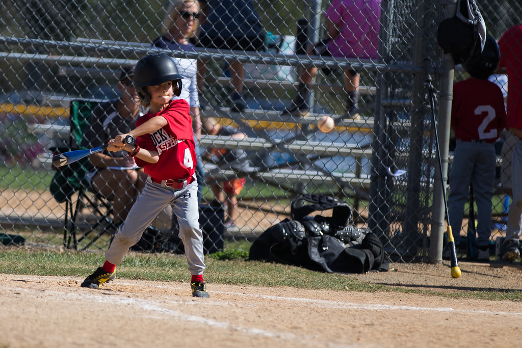 Kid taking batting practice in the cage